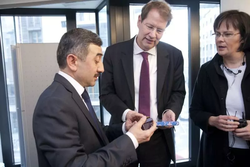 Gero Storjohann MdB (mitte) erhält ein ein Gastgeschenk von Ulugbek Mukhammadiev (links). Rechts Übersetzerin Birgit Heesel. Copyright: Deutscher Bundestag / Edgar Zippel   