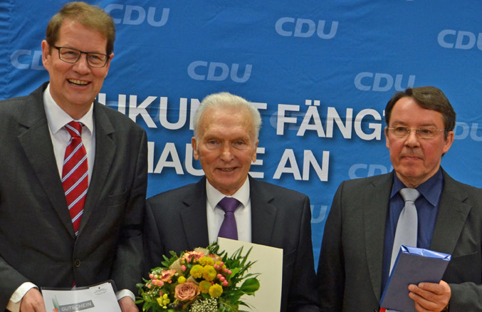 Gero Storjohann MdB  (links) überreicht die Einladung zur  Berlin-Reise und Dr. Manfred Hoffmann (rechts) überreicht die Urkunde zum Bürgerehrenpreis an Siegmar Gomille