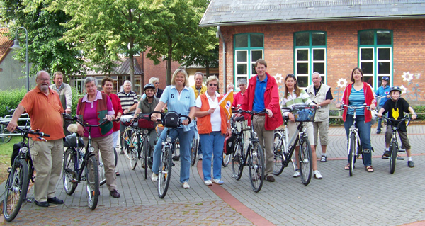 Bargfeld-Stegens CDU-Vorsitzende Ingrid Benthien gibt mit der CDU-Flagge das Startzeichen zur Fahrradtour. Der Bundestagsabgeordnete  Gero Storjohann und Ehefrau Maren (rechts neben Benthien) sind startbereit.