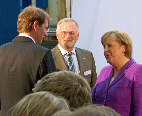 Der Bundestagsabgeordnete Gero Storjohann (CDU) begrüßt Bundeskanzlerin Angela Merkel bei  ihrem Besuch in Trappenkamp. In der Mitte: Dr. Jörn Biel (Minister für Wissenschaft, Wirtschaft und Verkehr des Landes Schleswig-Holstein.