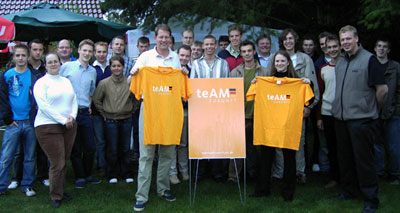 v.l.: Gero Storjohann und Anika Kersten präsentieren die neuen T-Shirts im kräftigen Orange des Angela-Merkel-Teams