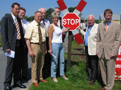 Das Stoppschild kombiniert mit dem Andreaskreuz. Wie die von ihm vorgeschlagene Beschilderung aussehen soll, demonstrierte Werner Kuhlmann (2. von rechts) an einem Bahnübergang in Verl Landrat Sven Georg Adenauer (CDU), dem Landtagsabgeordneten Dr. Michael Brinkmeier (CDU) sowie den Bundestagsmitgliedern Gerhard Wächter (CDU), Hubert Deittert (CDU), Heidi Wright (SPD) und Gero Storjohann (CDU) (von links).