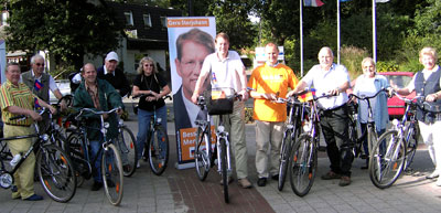 Der CDU-Kreisvorsitzende und Bundestagsabgeordnete Gero Storjohann (Mitte) und Jürgen Lamp, Ortsvorsitzender der CDU-Tangstedt im orangenen „teAM Zukunft Shirt“ mit einigen Teilnehmern der Radtour beim Start vor dem Tangstedter Rathaus.